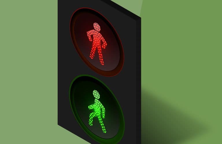 Ampel mit roter Fußgängerfigur oben und grüner Fußgängerfigur unten, vor grünem Hintergrund.