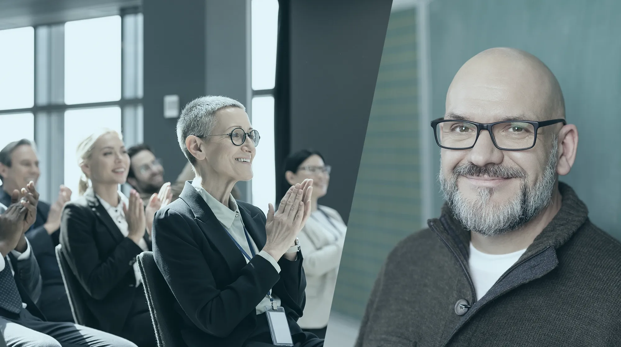 Das Publikum klatscht im Sitzen; rechts steht ein lächelnder Trainer mit Glatze und Brille.