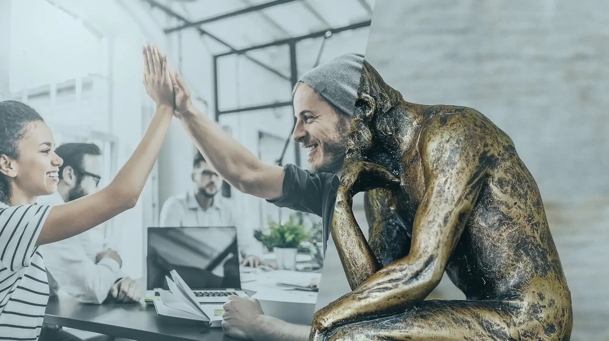 Eine Frau und ein Mann geben sich in einem Büro ein High-Five, und eine Statue, die einem Denker ähnelt, fügt sich in die Szene ein.